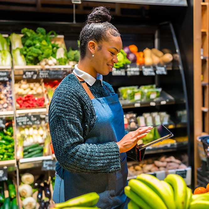 Saleswoman using digital tablet and managing inventory in organic supermarket
